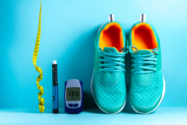 Running shoes next to a glucose meter and a smart pen and a waist measuring tape